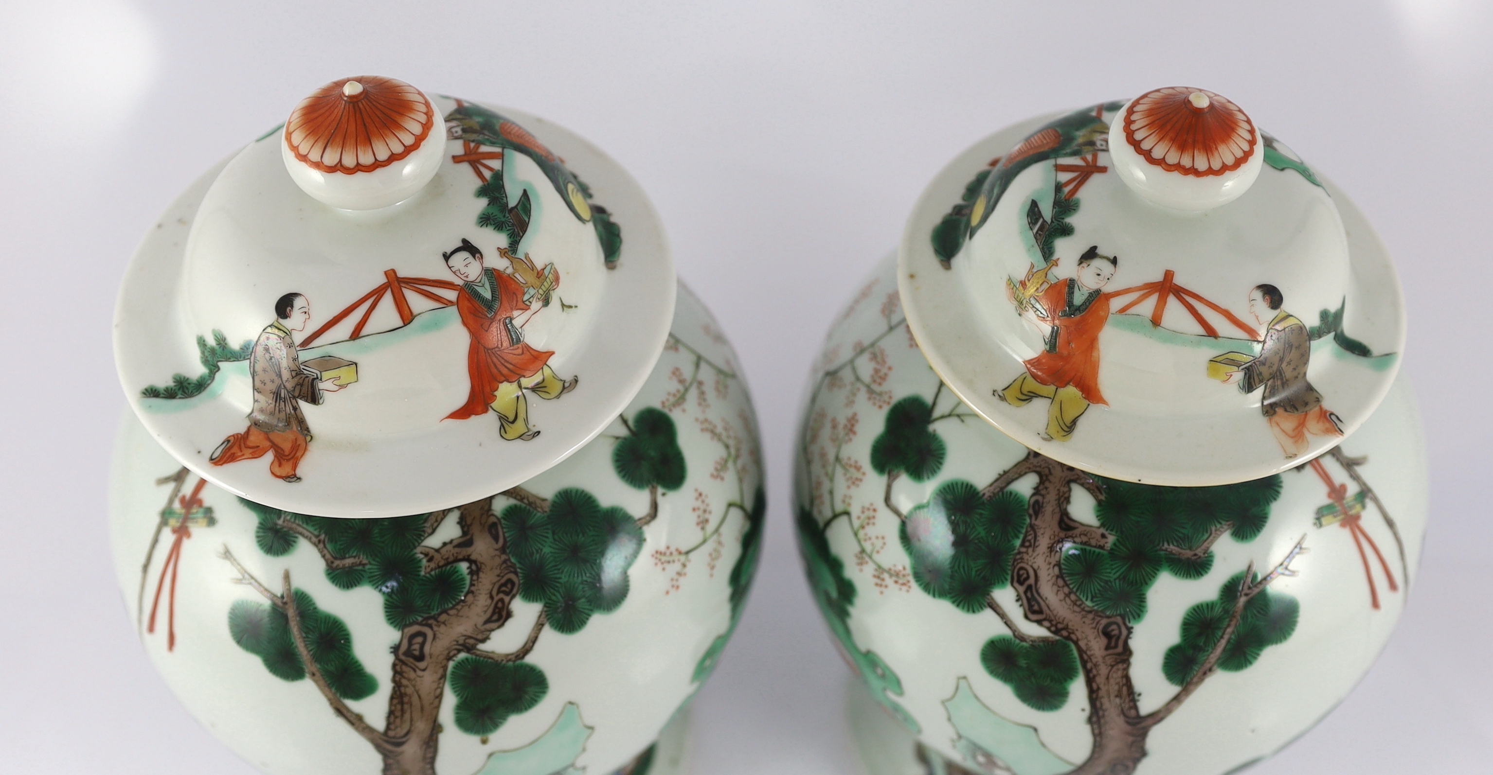 A pair of Chinese famille verte ‘Sanxing’ vases and covers, 19th century, some cracks